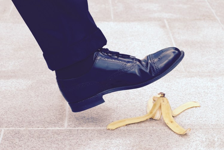 Businessman stepping on banana skin